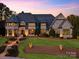 Elegant stone home with inviting landscape, lit walkway, and warm, inviting interior lights at 525 Lake Lynn Rd, Concord, NC 28025