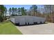 Large outbuilding with multiple garage doors surrounded by green grass and trees at 525 Lake Lynn Rd, Concord, NC 28025
