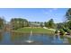 Picturesque view of estate home on green hill reflected in serene pond with fountain feature at 525 Lake Lynn Rd, Concord, NC 28025