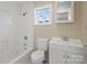 Well lit bathroom features a tub with shower, and a sink with white vanity and a mirror above at 703 Rankin Ave, Mount Holly, NC 28120