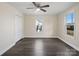 A cozy bedroom features modern floors, a ceiling fan, and ample natural light from two windows at 703 Rankin Ave, Mount Holly, NC 28120