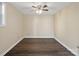 Spacious room with wood-look flooring, neutral walls, and a ceiling fan offers simple design at 703 Rankin Ave, Mount Holly, NC 28120