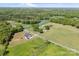 Wide aerial shot showing modern farmhouse with sprawling green fields at 7419 Tesh Rd, Monroe, NC 28110