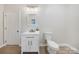 Clean bathroom with white vanity, toilet, sink, and hardwood floor at 7419 Tesh Rd, Monroe, NC 28110