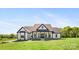 Beautiful modern farmhouse with lush green lawn on a sunny day at 7419 Tesh Rd, Monroe, NC 28110