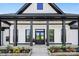 Inviting front porch with black accents, decorative columns, and colorful flowerbeds enhances curb appeal at 7419 Tesh Rd, Monroe, NC 28110