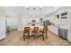 Bright kitchen featuring white cabinets, an island with seating, stainless steel appliances, and light wood flooring at 7419 Tesh Rd, Monroe, NC 28110