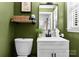 A half-bathroom with green walls, white trim, and a modern vanity with matte black hardware at 801 Glendora Dr, Charlotte, NC 28212