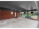 View of covered patio leading to brick home with concrete flooring and opening to an outdoor entertainment space at 801 Glendora Dr, Charlotte, NC 28212