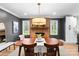 A dining room with a fireplace and modern light fixture above a wooden table with chairs at 801 Glendora Dr, Charlotte, NC 28212