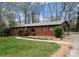 Charming brick home featuring a well-maintained lawn, inviting walkway, and a convenient carport at 801 Glendora Dr, Charlotte, NC 28212