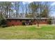 Charming front exterior of a single-story brick home with mature trees and landscaping at 801 Glendora Dr, Charlotte, NC 28212