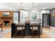Stylish kitchen island featuring seating, modern pendant lighting, and a view of the brick fireplace at 801 Glendora Dr, Charlotte, NC 28212