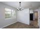 A view of dining area with modern lighting fixture, neutral paint, and view to the outside at 8125 Sheringham Way, Charlotte, NC 28227