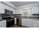 Bright kitchen features stainless steel appliances, white cabinetry, and a window above the sink at 8125 Sheringham Way, Charlotte, NC 28227