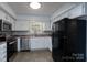 Well-lit kitchen with stainless steel appliances, double sink, and white cabinets at 8125 Sheringham Way, Charlotte, NC 28227