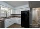 Spacious kitchen features white cabinetry, stainless steel appliances and a view of the backyard at 8125 Sheringham Way, Charlotte, NC 28227