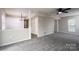 Spacious living area features a ceiling fan, neutral paint, and seamless transition to another room at 8125 Sheringham Way, Charlotte, NC 28227