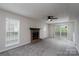 Cozy living room with a classic fireplace, ceiling fan, and sliding glass doors at 8125 Sheringham Way, Charlotte, NC 28227