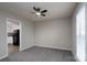 Comfortable living room with plush gray carpet, a modern ceiling fan, and natural light at 8125 Sheringham Way, Charlotte, NC 28227