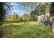 Large backyard featuring an expansive lawn, mature trees, and a patio with a seating area at 842 E Woodlawn Rd, Charlotte, NC 28209