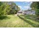 Spacious backyard featuring lush green grass, mature trees, and a partially visible brick-exterior home at 842 E Woodlawn Rd, Charlotte, NC 28209