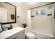Bathroom with tub and shower combination, framed mirror, and neutral walls at 842 E Woodlawn Rd, Charlotte, NC 28209