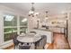 Dining area open to the kitchen, featuring hardwood floors, modern light fixtures, and skylights at 842 E Woodlawn Rd, Charlotte, NC 28209