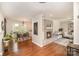 Open-concept living room with hardwood floors, brick fireplace and an adjacent dining area at 842 E Woodlawn Rd, Charlotte, NC 28209