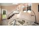 Well-lit living room with stairs, a tropical-themed rug, and a modern floor lamp at 842 E Woodlawn Rd, Charlotte, NC 28209