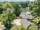 Aerial view of a lakeside home with solar panels, detached garage, and spacious driveway at 9500 Windygap Rd, Charlotte, NC 28278