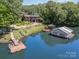 Aerial shot showcasing a waterfront home, dock, and boathouse on a serene lake setting at 9500 Windygap Rd, Charlotte, NC 28278