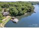 Scenic aerial view of a lakefront property featuring a house, boat dock, and lush green surroundings at 9500 Windygap Rd, Charlotte, NC 28278