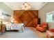 Charming bedroom featuring decorative wood paneling, a ceiling fan, and an inviting seating area at 9500 Windygap Rd, Charlotte, NC 28278