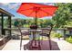 Outdoor deck furnished with table and chairs underneath a red umbrella, offering views of the lake at 9500 Windygap Rd, Charlotte, NC 28278