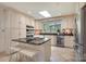 Bright kitchen with white cabinetry, granite countertops, island, and stainless steel appliances at 9500 Windygap Rd, Charlotte, NC 28278