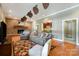 Spacious living room with brick fireplace, kitchenette, comfortable seating, and decorative ceiling fans at 9500 Windygap Rd, Charlotte, NC 28278
