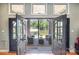 Covered patio with comfortable seating, stylish rug, and beautiful views of the lake through glass doors at 9500 Windygap Rd, Charlotte, NC 28278