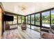 Bright sunroom features walls of windows offering scenic lake views, comfortable seating, and modern ceiling fan at 9500 Windygap Rd, Charlotte, NC 28278