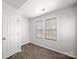 This bedroom features a window, wood-look floors, and a door at 10031 Orchard Grass Ct, Charlotte, NC 28278