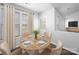 Bright dining room featuring a wooden table with four chairs, a vase with flowers, and bright natural light at 10031 Orchard Grass Ct, Charlotte, NC 28278