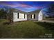 Charming single-story home with white siding, black shutters, and a well-maintained lawn at twilight at 10031 Orchard Grass Ct, Charlotte, NC 28278