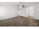 A large living room featuring a modern ceiling fan and dark wood-look floors at 10031 Orchard Grass Ct, Charlotte, NC 28278