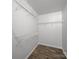 Walk-in closet with hanging racks and wood-look flooring at 10031 Orchard Grass Ct, Charlotte, NC 28278