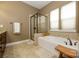 Bathroom showcasing a soaking tub, glass enclosed shower, and double windows for natural light at 1022 Bimelech Dr, Indian Trail, NC 28079