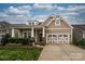 Charming home featuring a two-car garage, covered porch with stone accents, and manicured lawn at 1022 Bimelech Dr, Indian Trail, NC 28079