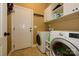 A well-lit laundry room featuring a washer and dryer, overhead cabinets, and convenient access to the exterior at 1022 Bimelech Dr, Indian Trail, NC 28079