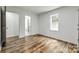 A well-lit bedroom with wood floors and a view to an adjoining bathroom exudes a clean, modern aesthetic at 1022 Parker St, Monroe, NC 28112
