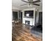 Spacious living room with fireplace, flat-screen TV, ceiling fan, and beautiful wood floors at 1022 Parker St, Monroe, NC 28112