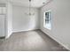 Bright dining room with a modern chandelier, neutral carpet, and natural light at 10827 Azure Valley Pl, Charlotte, NC 28269